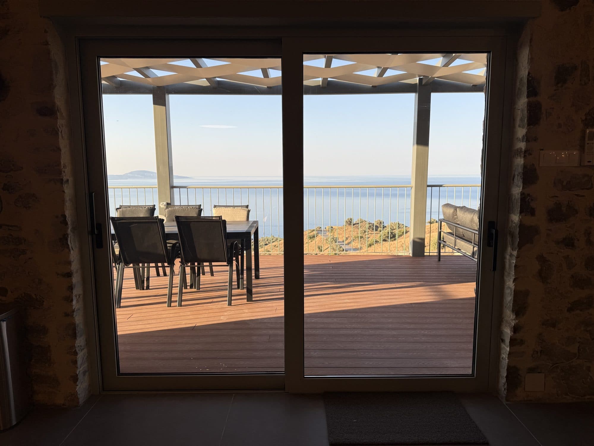 The sea-view terrace framed by the sliding glass doors