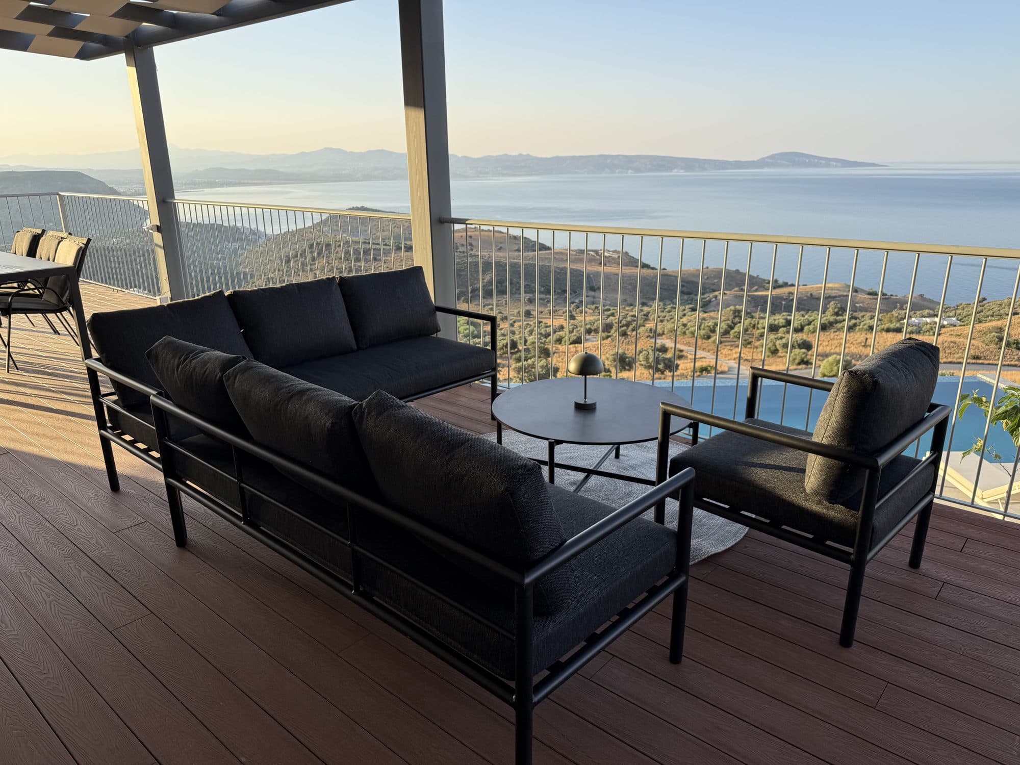 Outdoor lounge on the terrace beside the infinity pool and sea